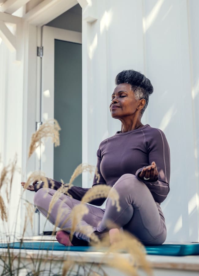 Resident doing yoga outside at Creekside Village Senior Apartment Homes in Pittsburg, California