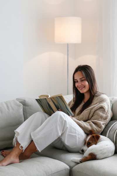 Resident reading a book on a couch at Sand Pebble and Spanish Oaks in Sparks, Nevada