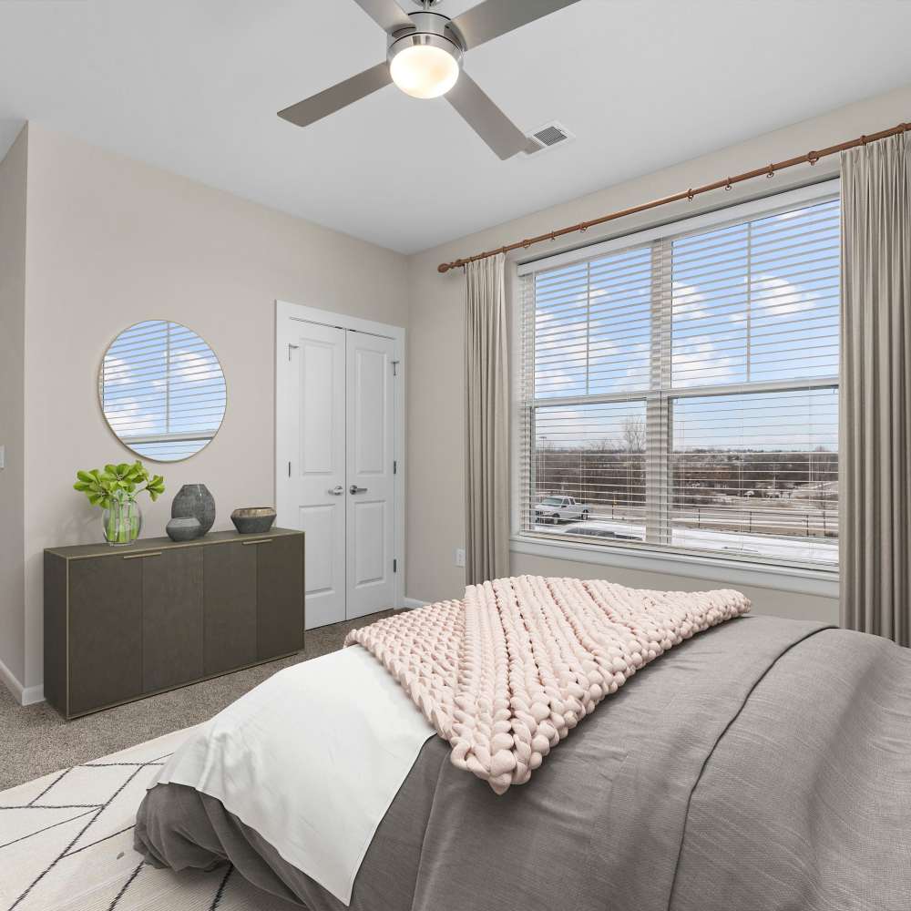 Bedroom with a large window and a ceiling fan at Citrine at Lake St. Louis in Lake Saint Louis, Missouri