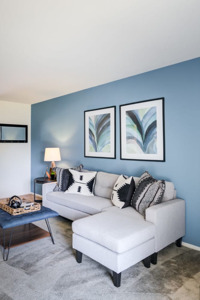 Model living room with wall-to-wall carpeting at Mapleton Square Apartment Homes in Dover, Delaware