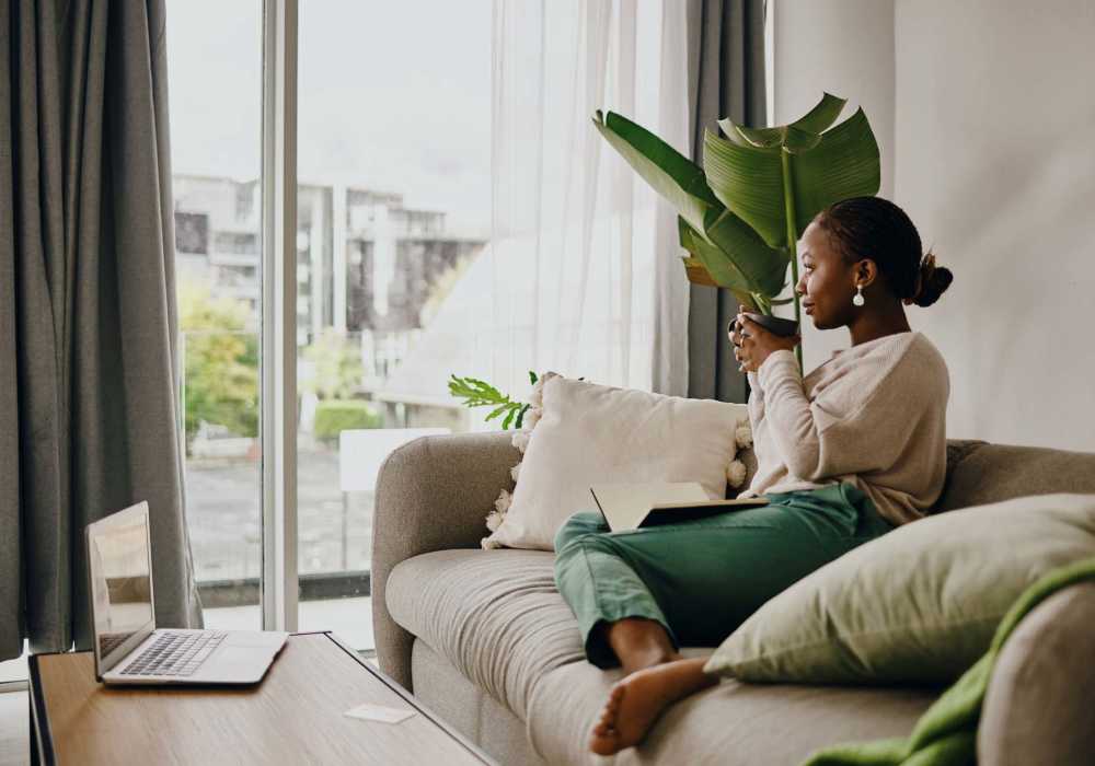 A woman having cup of coffee in a couch at Silo Creek Apartments in Lafayette, Louisiana