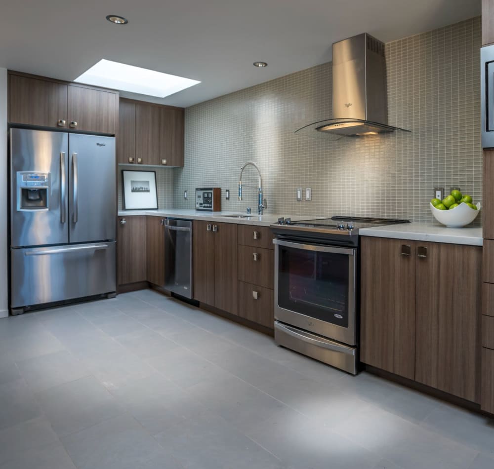Quartz countertops and espresso wood cabinetry in a model home's kitchen at Panorama Apartments in Seattle, Washington