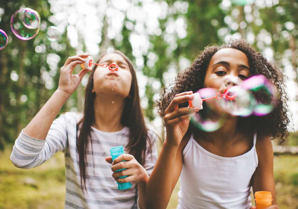 Children blowing soap bubbles in a park near Main Street Apartments in Bensenville, Illinois