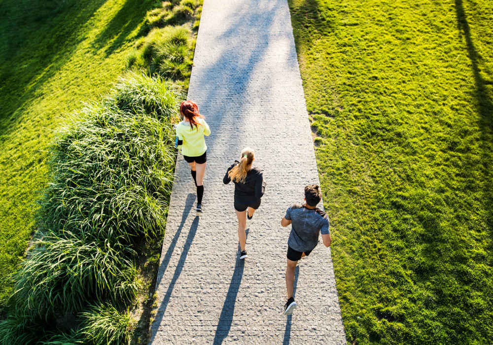 A group of friends running through a park near Ascent Apartment Homes in Asheville, North Carolina