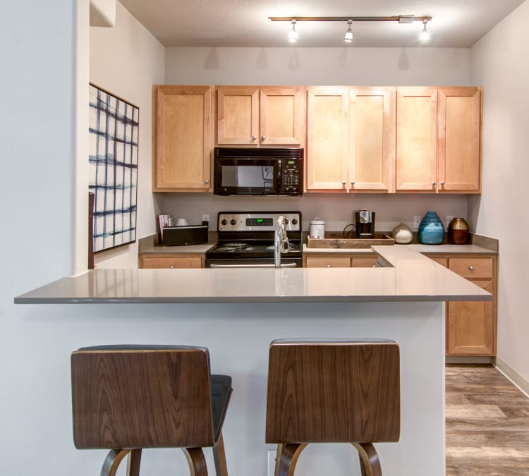 Quartz countertop and stainless-steel appliances in a model home's kitchen at Sofi at Forest Heights in Portland, Oregon