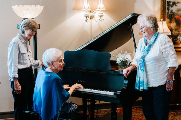 Three residents enjoying the piano at Wesley Gardens in Montgomery, Alabama