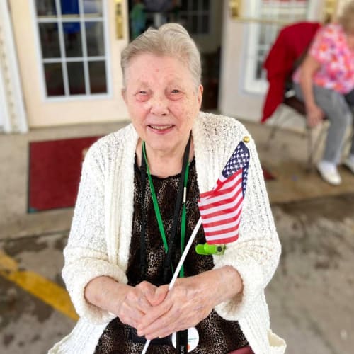 Smiling resident with flag at Canoe Brook Assisted Living in Broken Arrow, Oklahoma