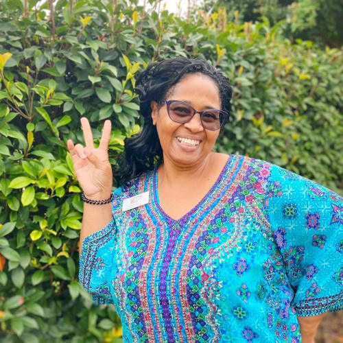 Team member smiling and holding the peace sign at Oxford Glen Memory Care at Carrollton in Carrollton, Texas