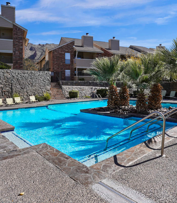 Sparkling pool and sundeck outside of The Chimneys Apartments in El Paso, Texas