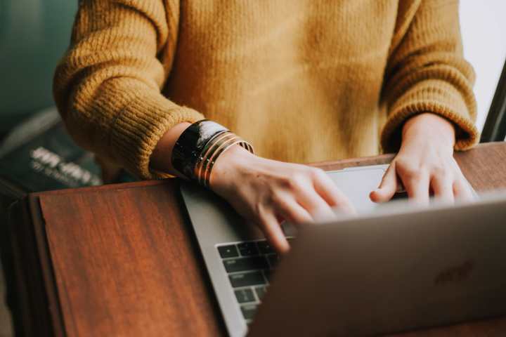 upclose image of a person typing on a laptop
