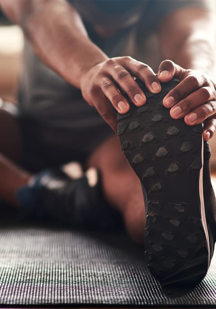 A man stretching on a yoga mat at Hunt Club in Gaithersburg, Maryland