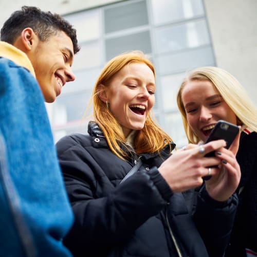 Three friends looking at a phone near Union SLU in Seattle, Washington