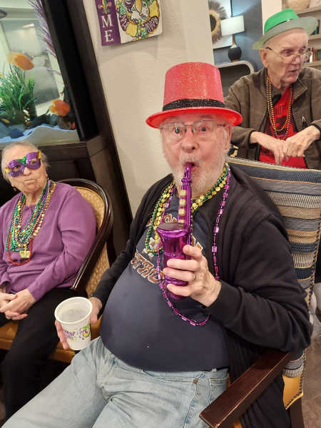Celebrate life at The Landing at Watermere Frisco! Residents enjoy fun-filled community events like this festive Mardi Gras party, fostering joy, connection, and a vibrant social atmosphere in a welcoming senior living environment.