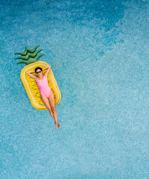 Resident on pineapple floatie in pool at Playa Del Oro, Los Angeles, California 