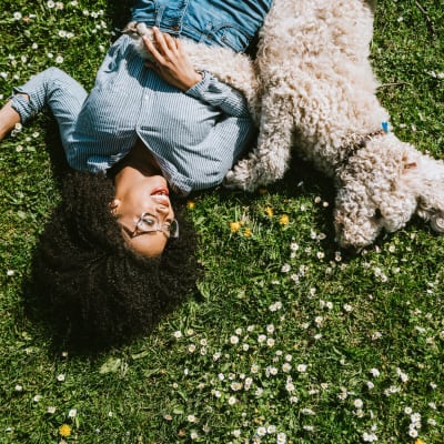 A resident laying in the grass with her dog at Columbia Colony in Patuxent River, Maryland