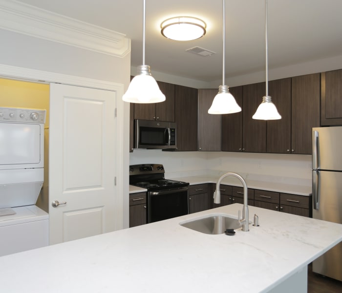 Open gourmet kitchen with adjacent washer and dryer in model home at Aqua on 25th in Virginia Beach, VA