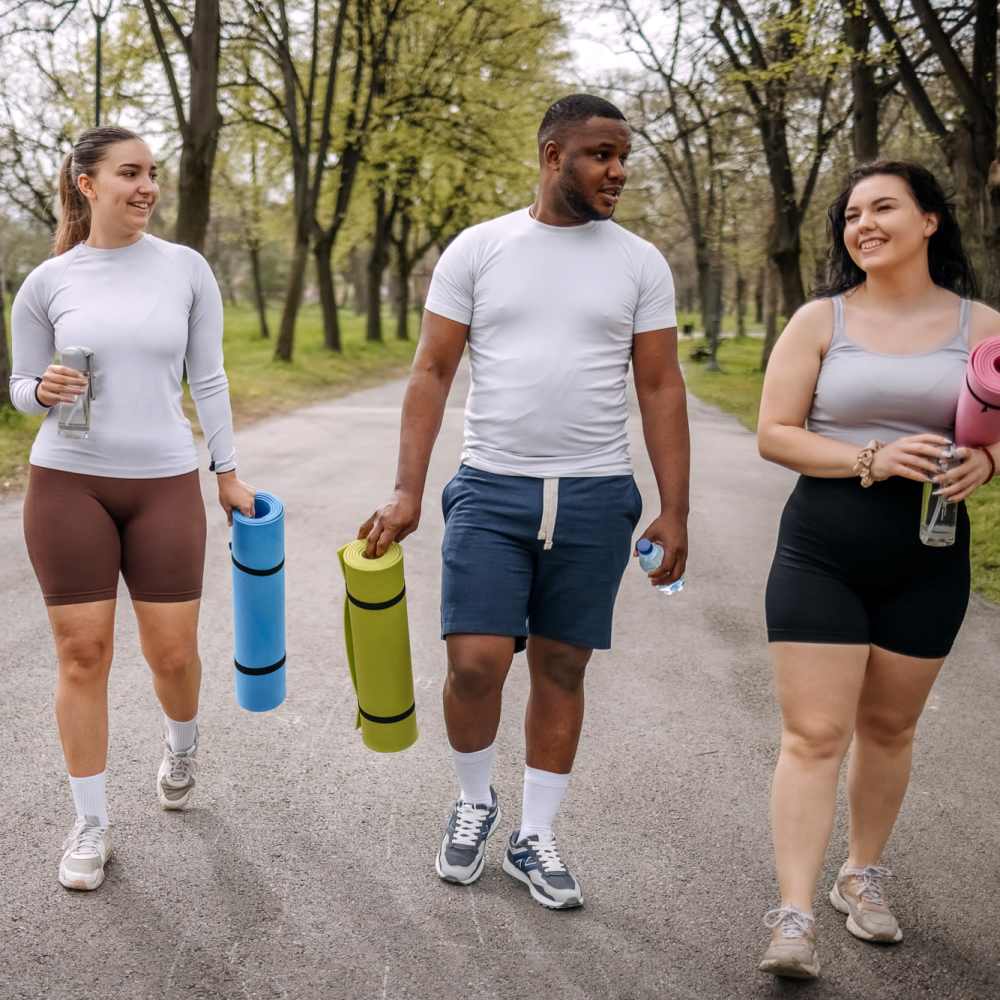 Friends walking with yoga mats at Niner Woods in Charlotte, North Carolina