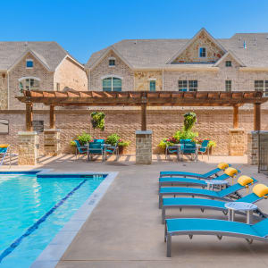 pool with chairs on patio at Atlas Point at Prestonwood in Carrollton, Texas