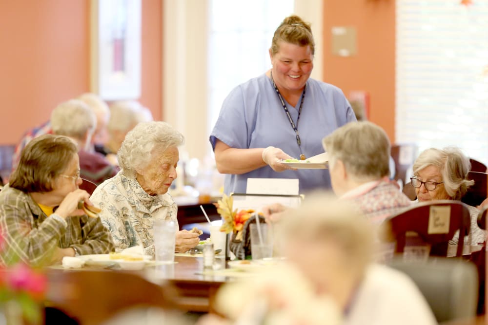 A staff member helping with dinner at Providence Assisted Living. 