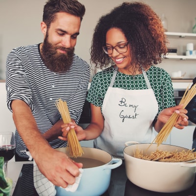 Resident couple cooking up something delicious in their modern kitchen at Auro Crossing in Austin, Texas