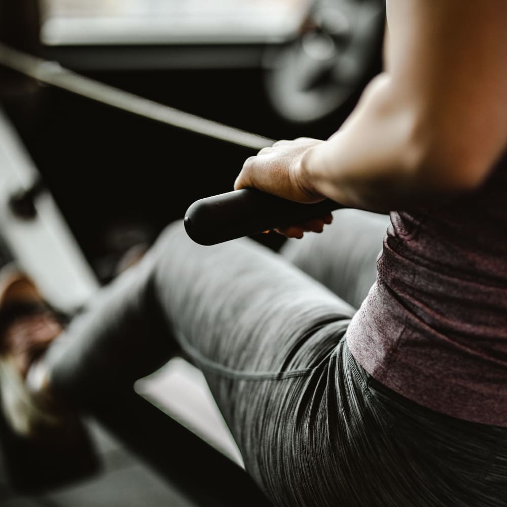 A resident using a rowing machine in the fitness center at The Legends on the Park in Eureka, Missouri