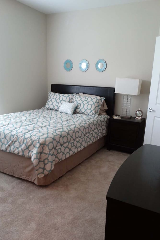 Bedroom with plush carpet flooring at Oak Grove Crossing Apartments in Newburgh, Indiana
