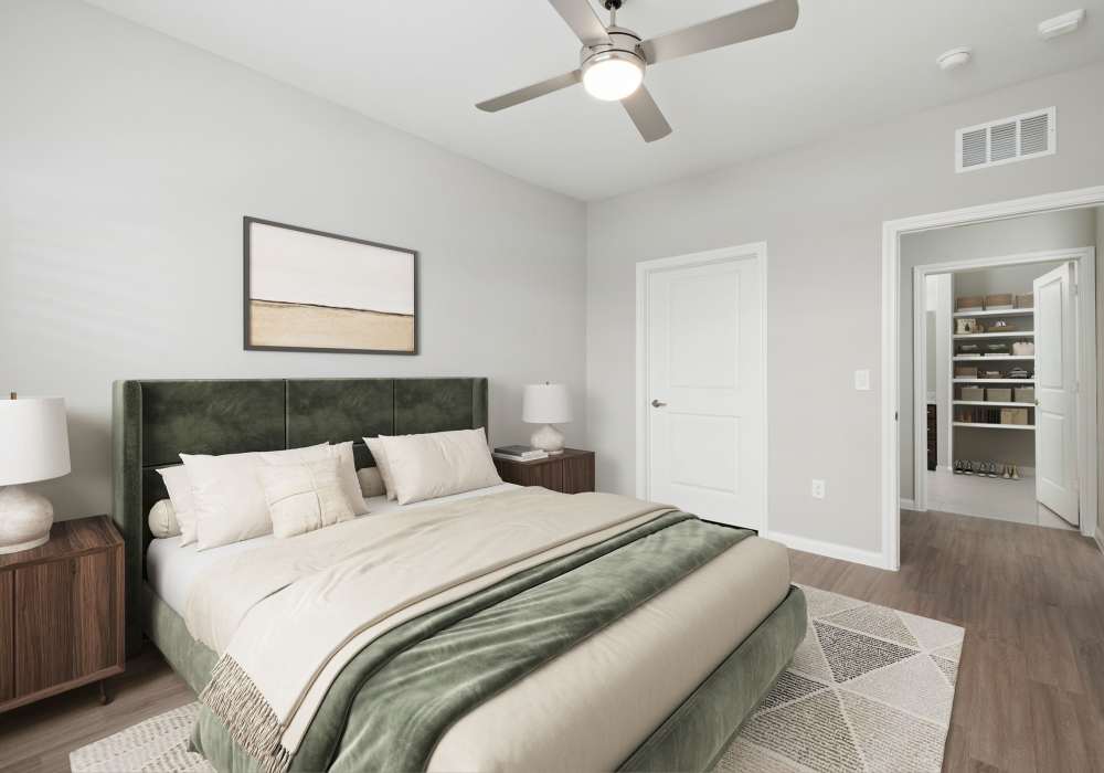Model bedroom with wood-style flooring at Walnut Springs in Seguin, Texas