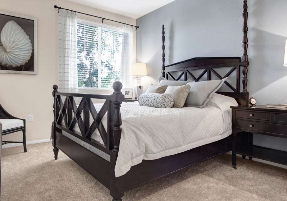 Spacious bedroom with large comfortable bed, desk, and large window at Rivers Edge in Lake Elsinore, California