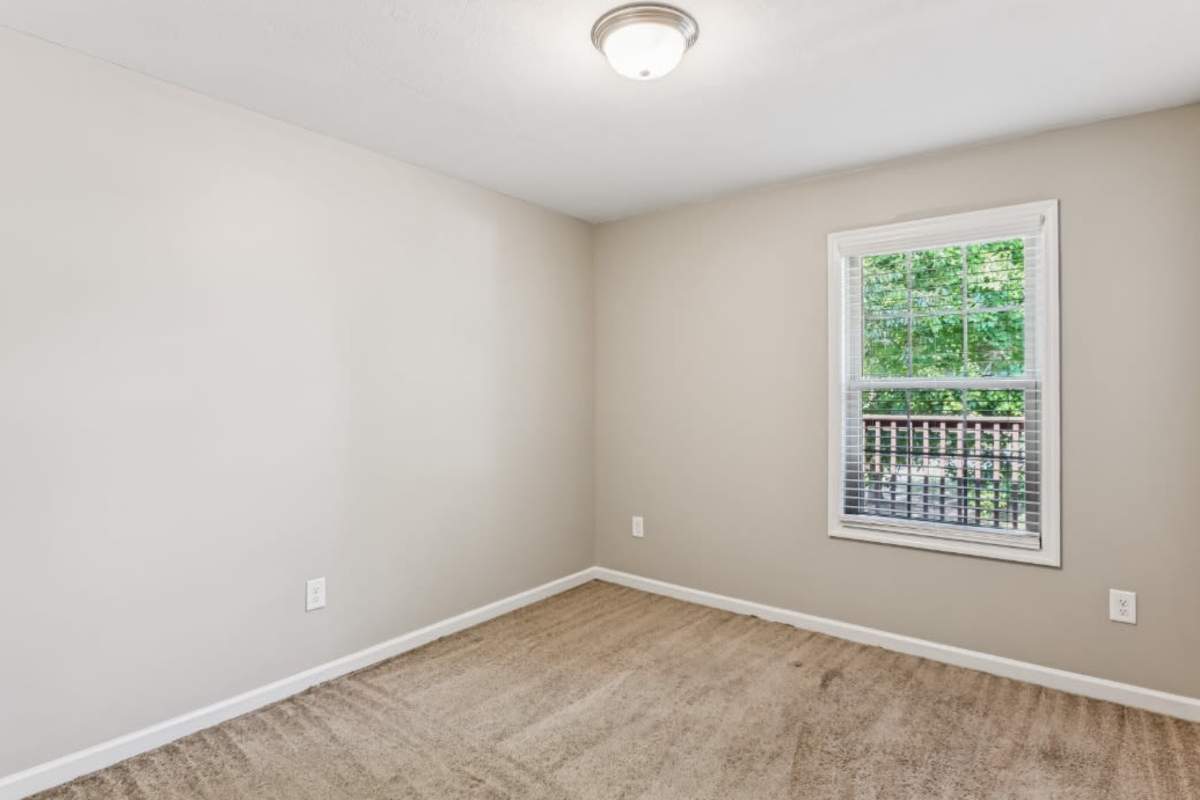 Resident bedroom with plush carpeting at Ashford Place in Clarksville, Tennessee