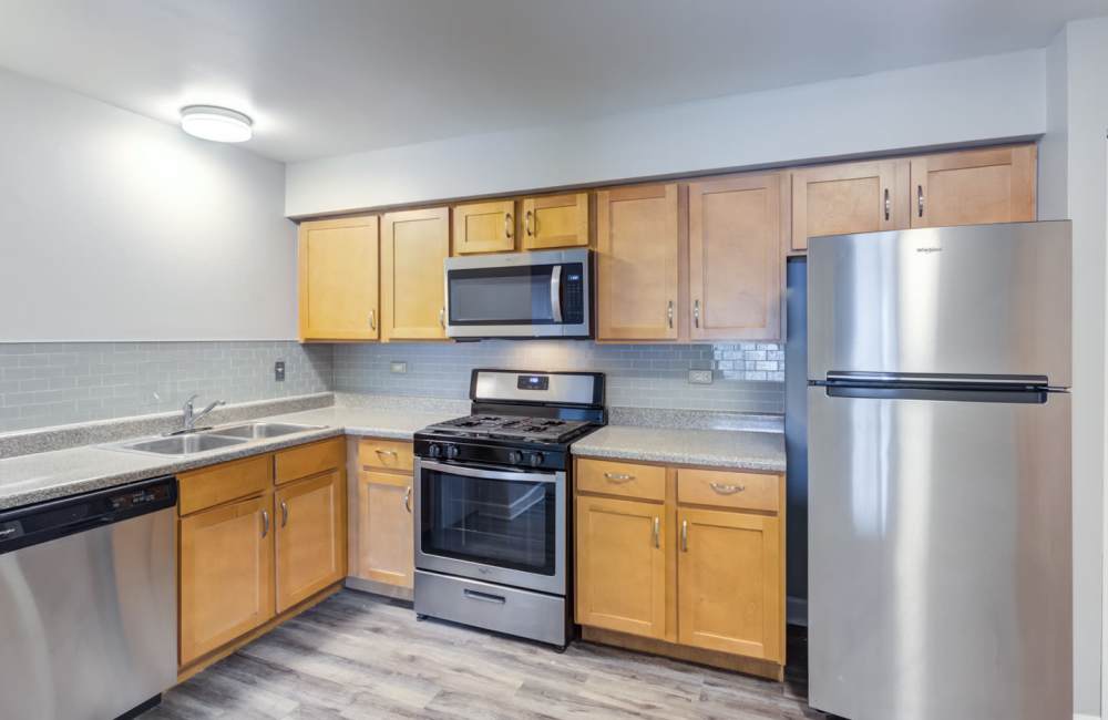 Fully equipped kitchen with white appliances at The Gates of Deer Grove Apartment Homes in Palatine, Illinois