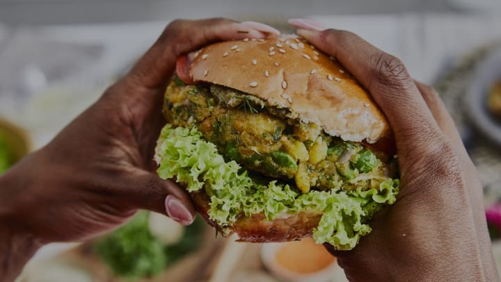 patron holding a veggie burger | vegan restaurants in Albuquerque