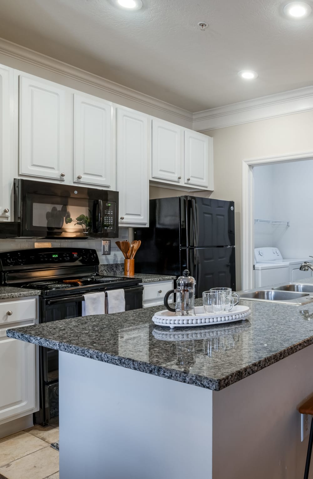 Kitchen with white cabinets, granite countertops, black appliances at Easton Commons Apartments & Townhomes in Columbus, Ohio