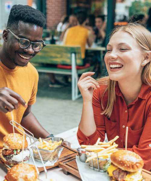 Residents enjoying food at a restaurant near Woodmere Apartments of Venice in Venice, Florida