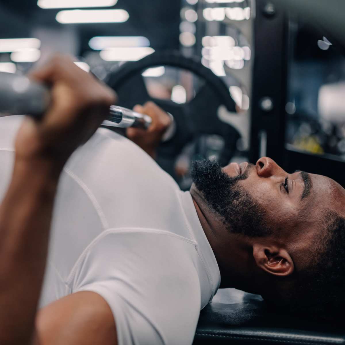 Man lifting weights in fitness center at Villas at Mulberry Way in Kalamazoo, Michigan 