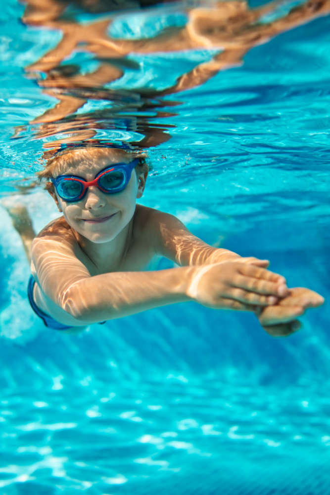 A kid swimming in a pool at Green Tree Place in Houston, Texas