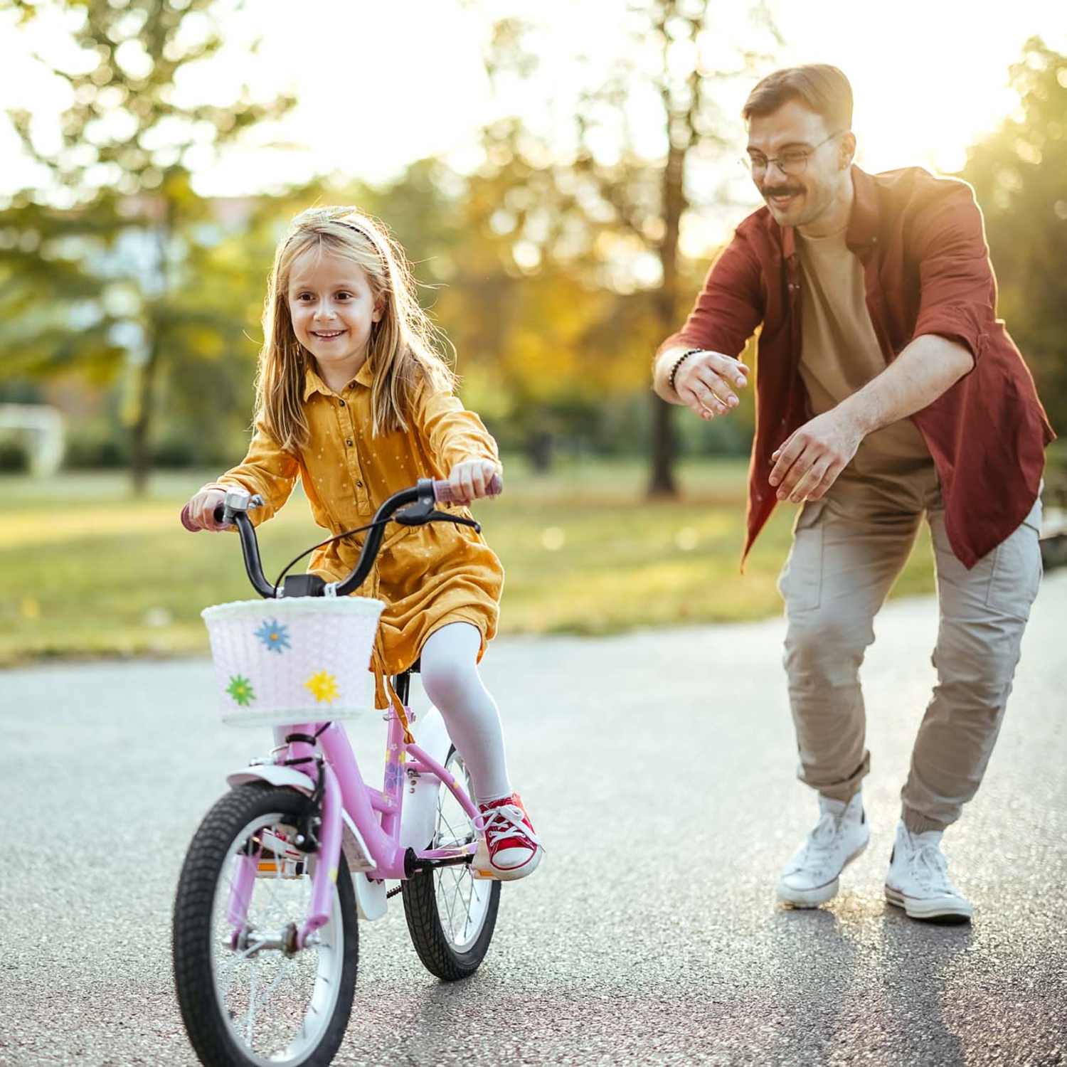 Resident kid practicing cycling with help of her father in a local park near The Waterford in Morrisville, North Carolina