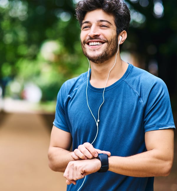 A man touching his watch after a run in a park near The Highland in Augusta, Georgia