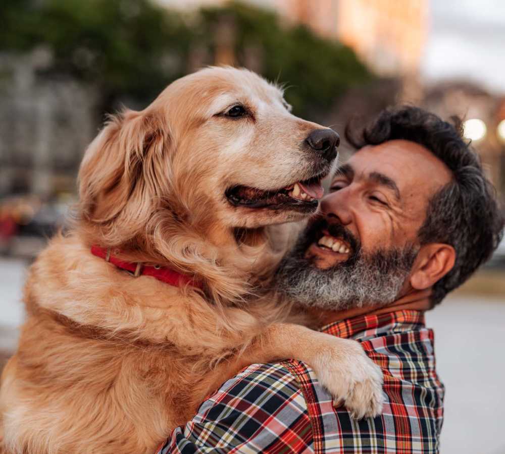 Resident holding his dog in his arms near Vintage at Redfield in Reno, Nevada