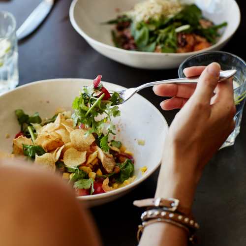 Woman having salad at a restaurant nearby UTE Creek Apartments in Longmont, Colorado