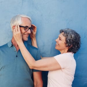 Resident putting glasses on her partners face at Atlas Point at Prestonwood in Carrollton, Texas