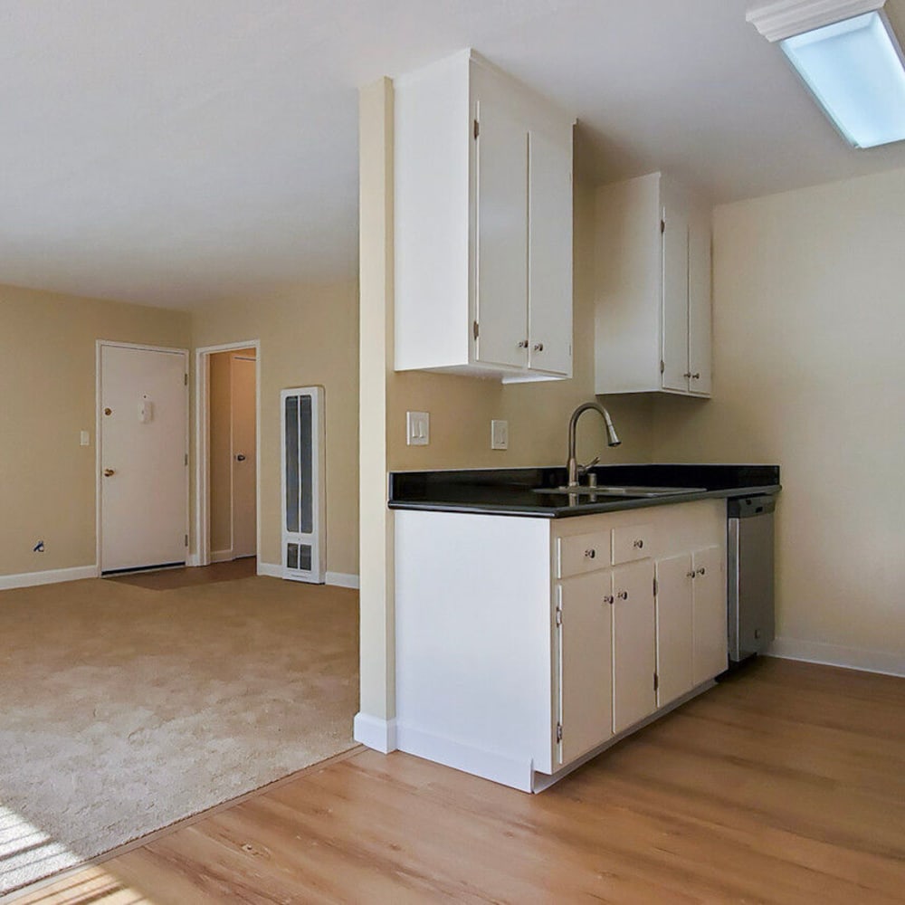 Hardwood-style flooring and white cabinetry in a model apartment home's kitchen at Mission Rock at San Rafael in San Rafael, California