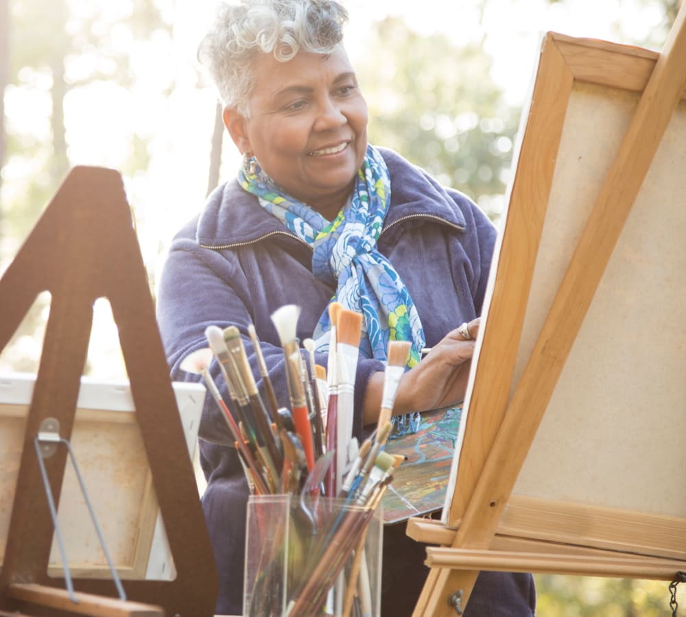 Resident painting a picture on an easel at Skyline Place Senior Living in Sonora, California