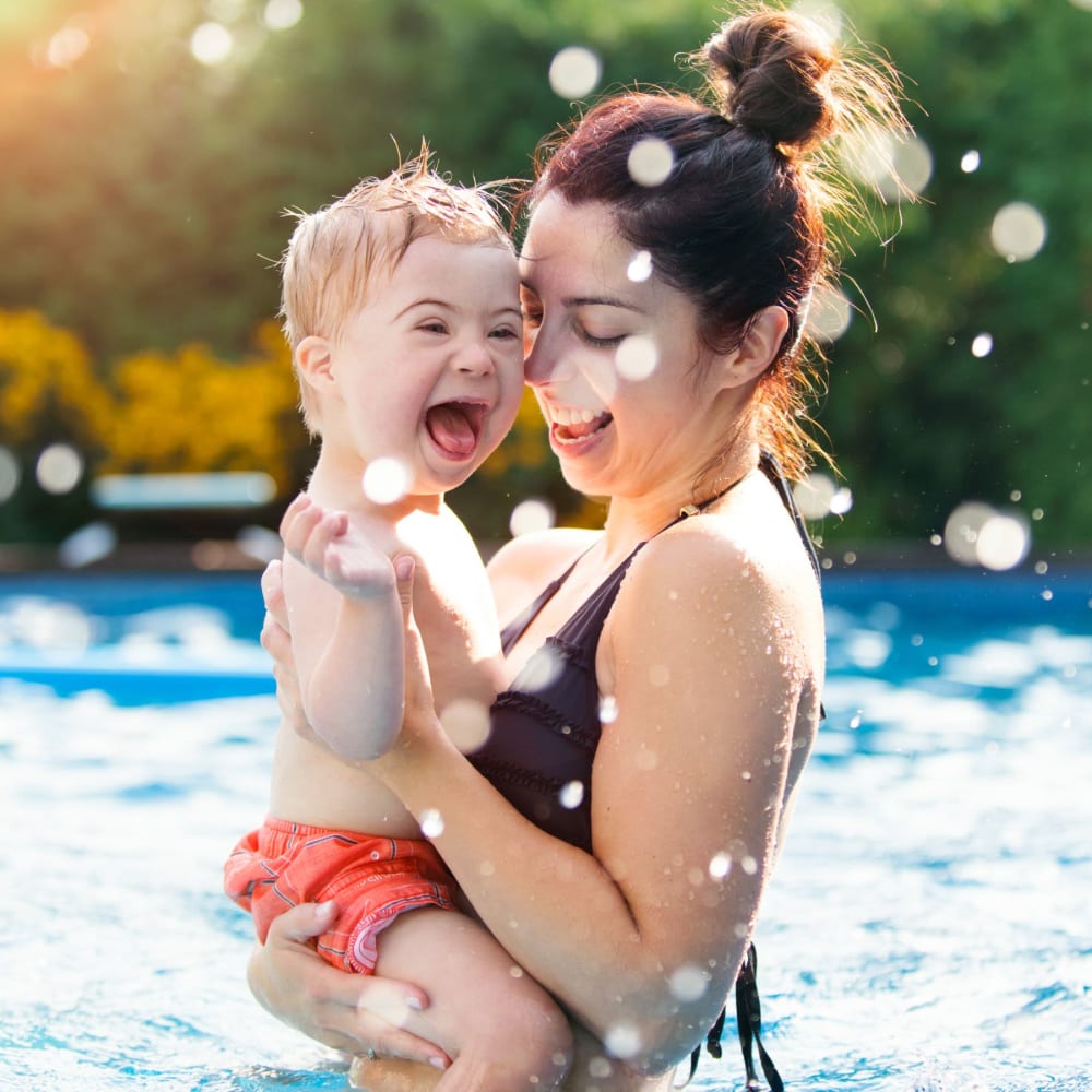 A woman holding a child in in the pool at Amber Oaks in Durham, North Carolina
