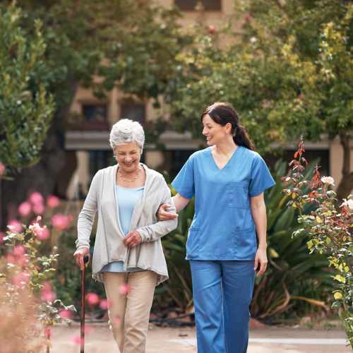 Resident and memory care team member walking at Hilltop Senior in Irvington, New Jersey