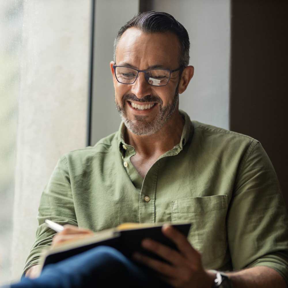 Man writing in a notebook at Westmoreland Apartments in Los Angeles, California