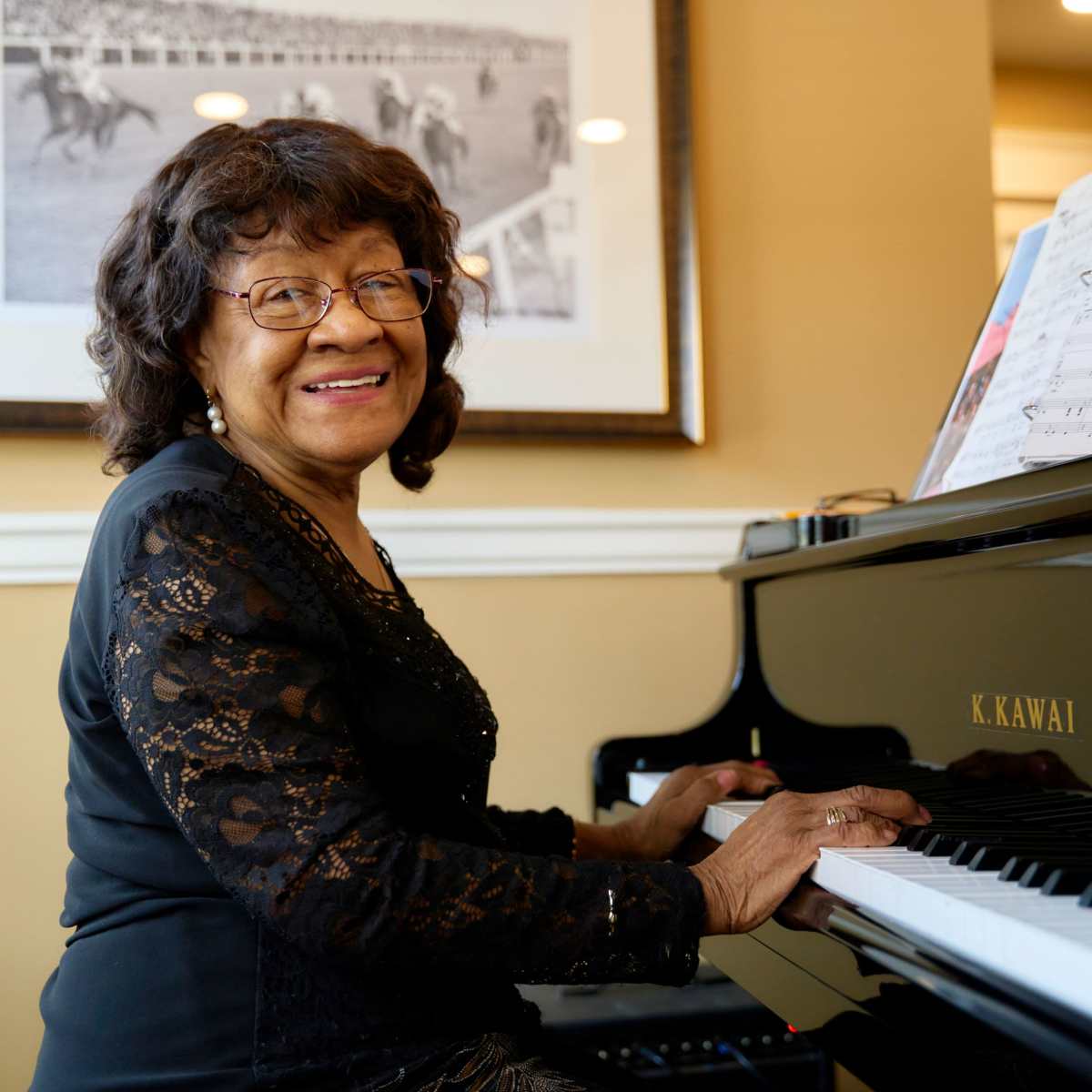 Resident playing the piano at Harmony at Harts Run senior living community