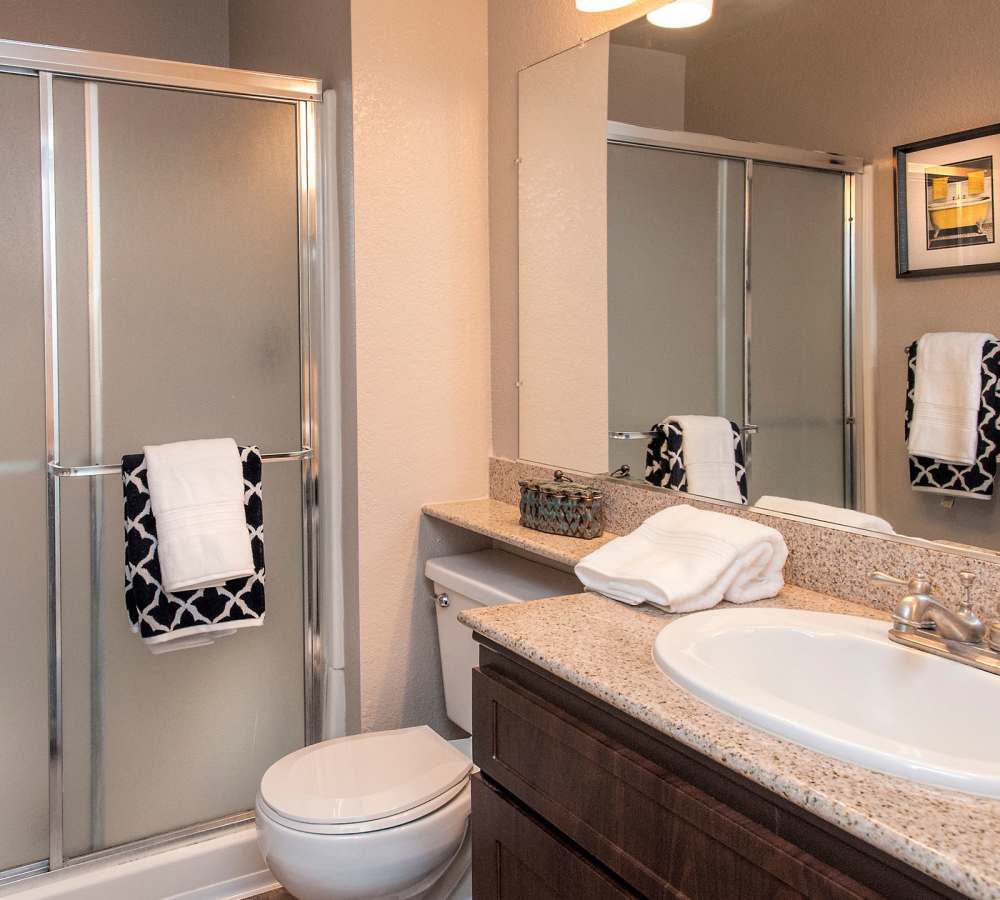 Upgraded bathroom with stone countertops and upgraded cabinetry at Deer Valley Apartment Homes in Roseville, California