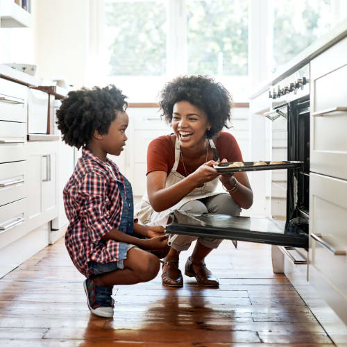 Mom and child have fun baking at their home at Palisades Sierra Del Oro in Corona, California