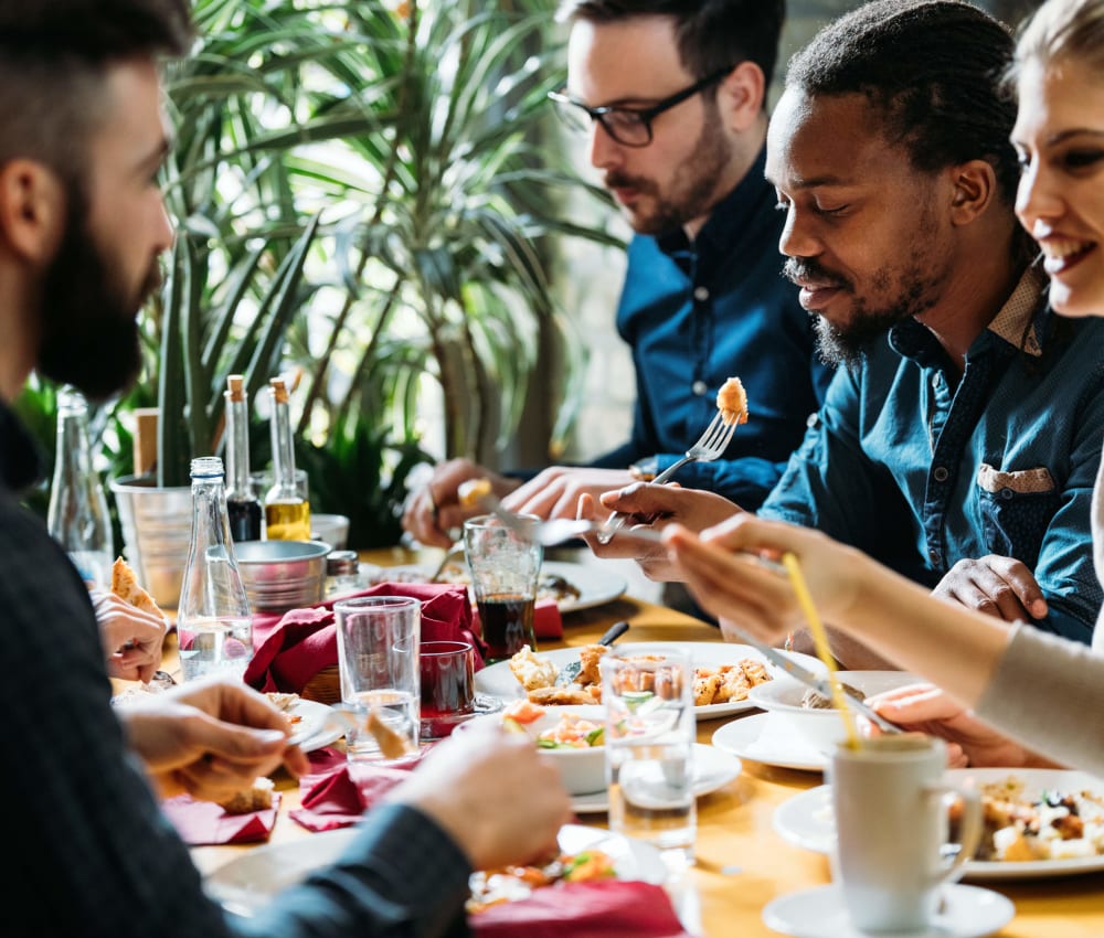 Group of resident friends out for a meal at their favorite restaurant and raising a toast to the good life at Anson in Burlingame, California