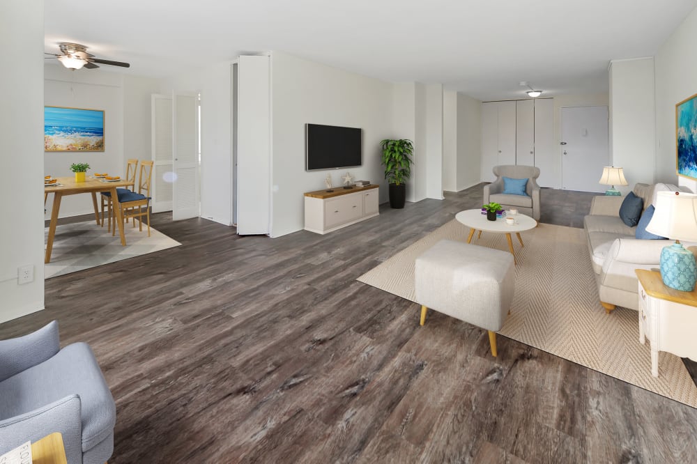 Staged living and dining rooms in a renovated apartment with hardwood-style flooring